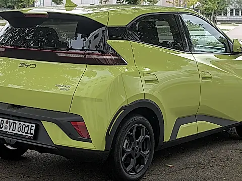 BYD Dolphin Surf Comfort: limettengrüner Elektro-Kleinwagen schräg von hinten am Straßenrand