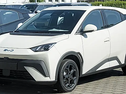 BYD Dolphin Surf Leasing: weißer Elektro-Kleinwagen schräg von vorn in einer Fahrzeugreihe auf einem Hof