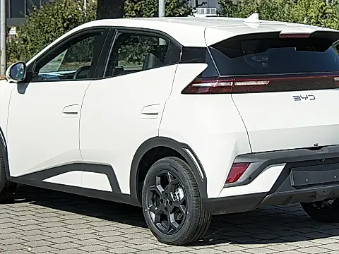 BYD Dolphin Surf Preis: weißer Elektro-Kleinwagen schräg von hinten auf einem gepflasterten Hof