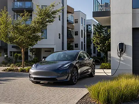 Elektroauto wird zu Hause an der Wallbox geladen, daneben eine öffentliche Schnellladesäule als Kostenvergleich