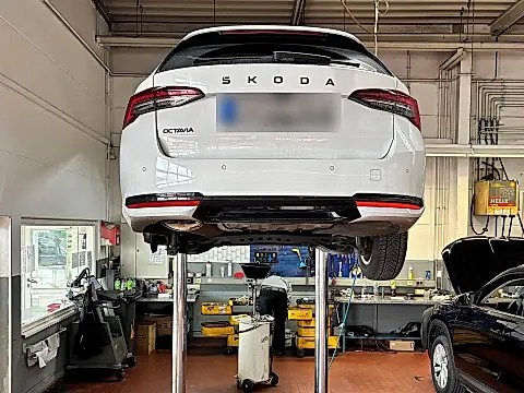 Škoda Rückrufaktion Lenkung: weißer Škoda Octavia Combi auf der Hebebühne in einer Werkstatt