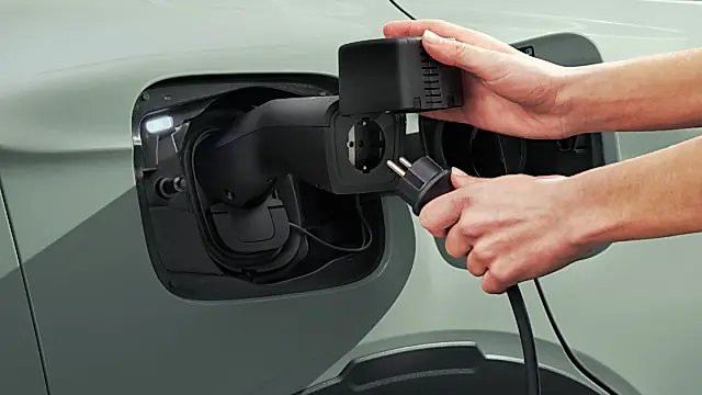 Skoda V2L Adapter am Ladeanschluss: ein Schuko-Stecker wird in die Steckdose des Adapters gesteckt