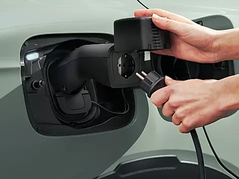 Skoda V2L Adapter am Ladeanschluss: ein Schuko-Stecker wird in die Steckdose des Adapters gesteckt